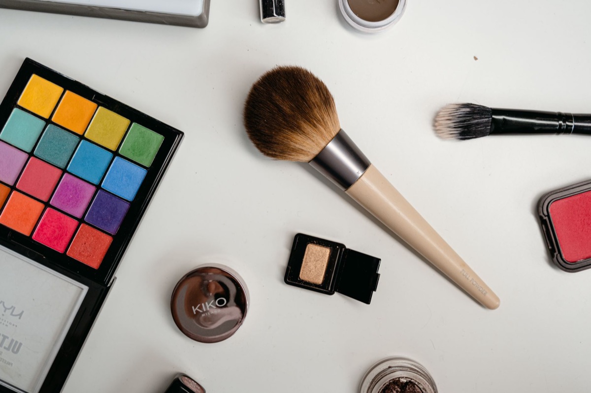Kleurrijke make-up penselen en oogschaduw paletten.