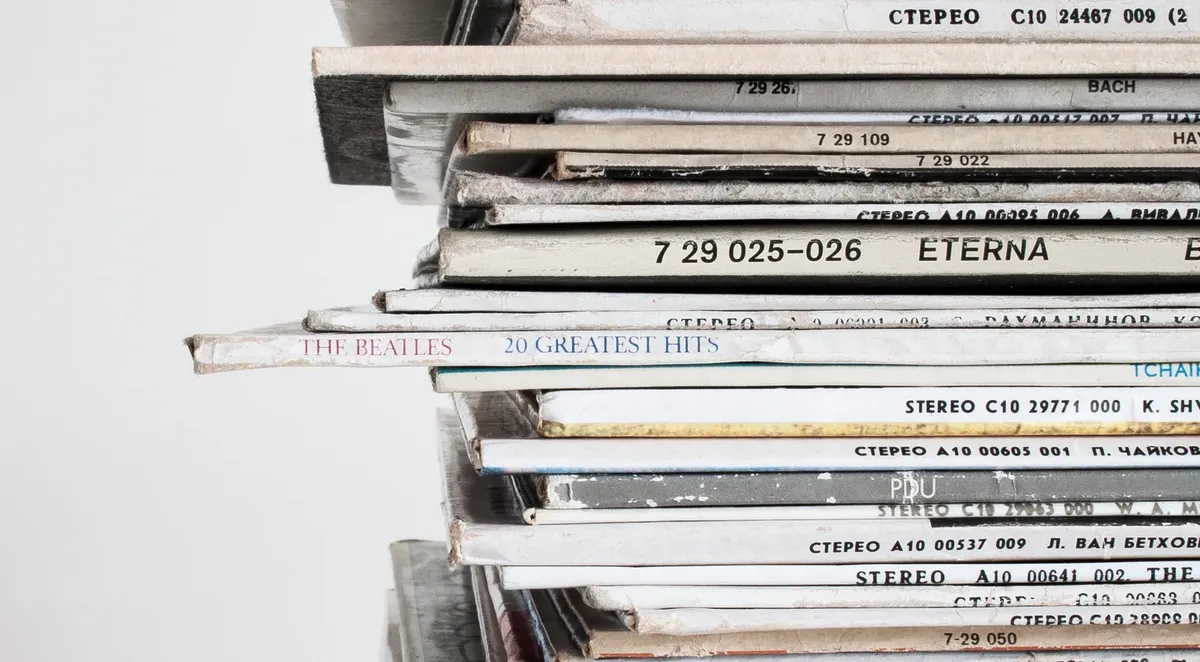 Close-up shot of a stacked pile of vintage vinyl record albums showcasing classic music covers.