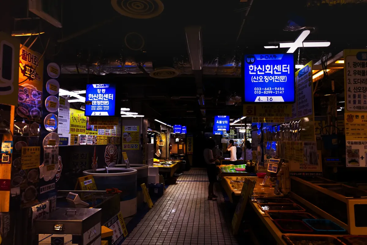 Explore the bustling atmosphere of a Korean fish market in Gangneung, filled with fresh seafood offerings.