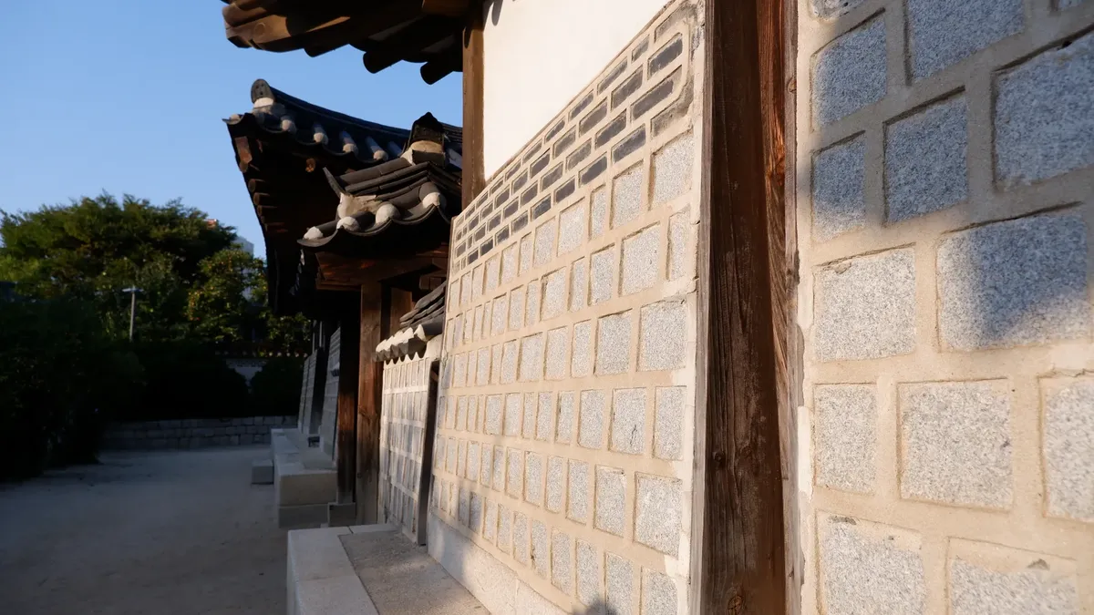 A close-up of a traditional Korean building with distinctive tiled roofs and stone walls, capturing cultural heritage.