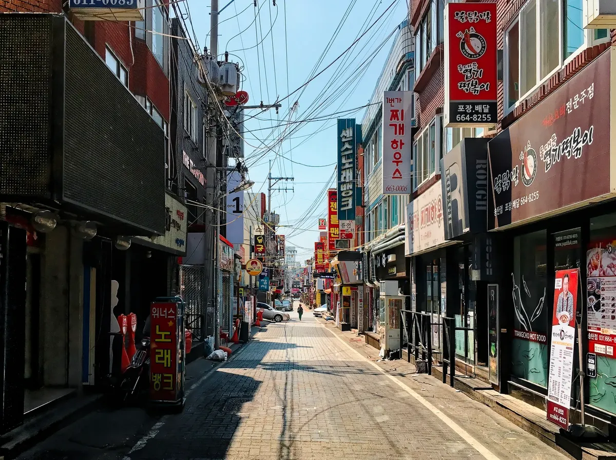 朝の韓国の賑わいの通り、色とりどりの看板と店舗
